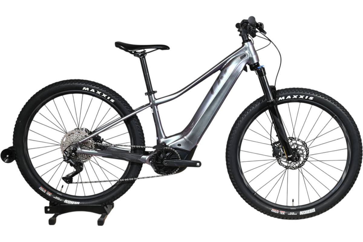 Velo electrique VTT Giant Liv Vall E+2 2025 gris argent de Loop Sports sur socle en bois