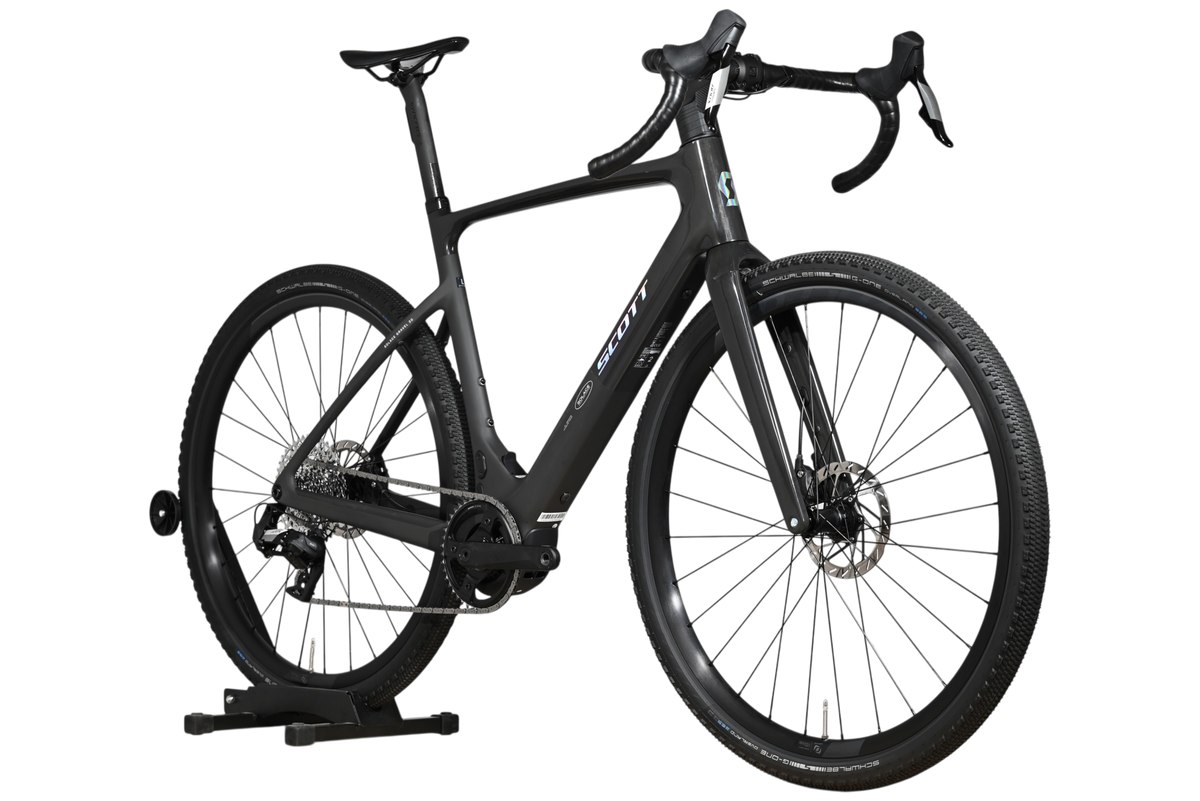 Vélo de gravel électrique noir Scott Solace Gravel eRide 30 de Loop Sports sur un support en bois