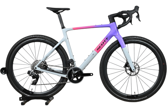 Vélo de gravel Scott Addict Gravel 20 2026 de Loop Sports avec cadre dégradé violet et rose sur fond blanc