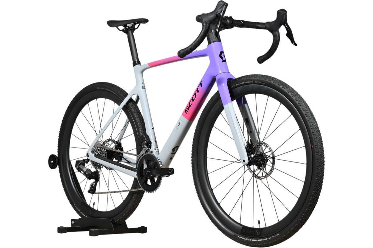 Vélo de gravel Scott Addict Gravel 20 2026 de Loop Sports avec cadre dégradé violet et gris sur support en bois