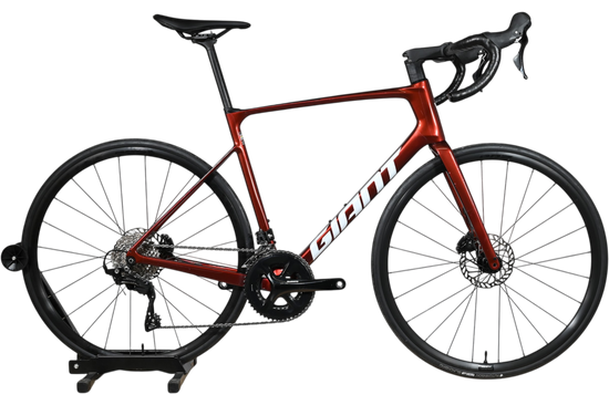 Vélo de route Giant Defy Advanced 2 2025 rouge bordeaux chez Loop Sports sur socle en bois