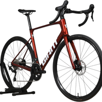 Vélo de route Giant Defy Advanced 2 2025 rouge métallique chez Loop Sports sur support en bois
