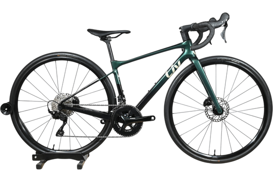 Vélo de route Giant Liv Avail Advanced 2 2025 vert foncé chez Loop Sports sur un support en bois