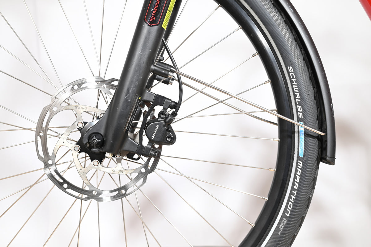 Gros plan sur le frein à disque hydraulique Tektro et la roue avant du vélo électrique Victoria E-Trekking 8.8 Loop Sports