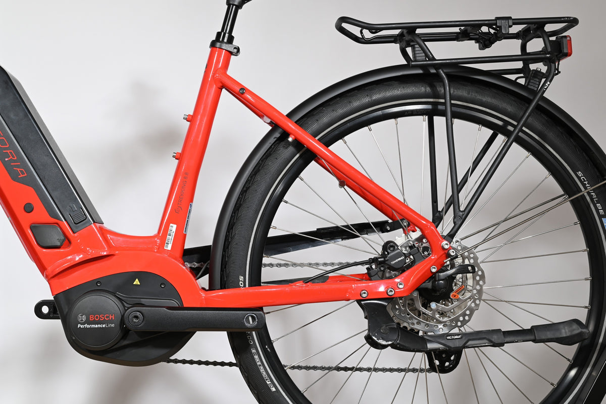 Gros plan sur le cadre rouge et la roue arrière du vélo électrique Victoria E-Trekking 8.8 de Loop Sports