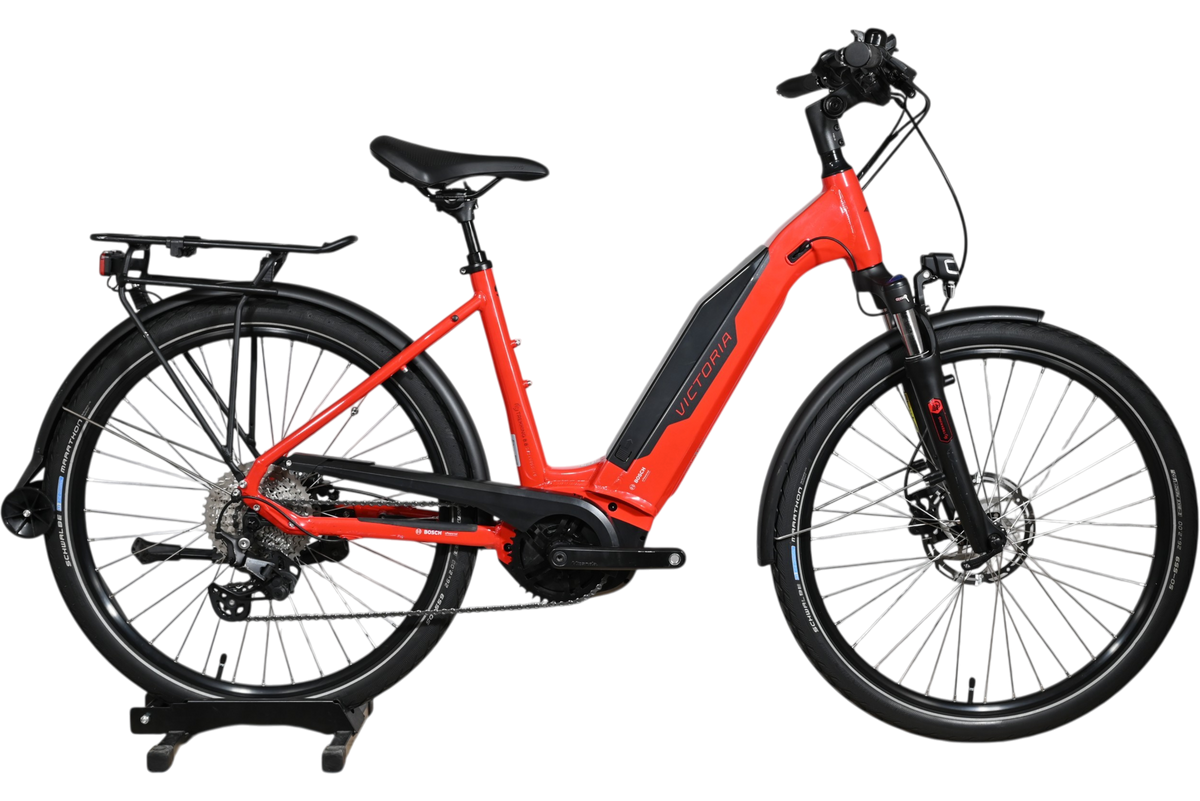 Vélo électrique de trekking rouge Victoria E-Trekking 8.8 de Loop Sports avec cadre bas et porte-bagages arrière