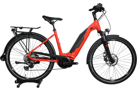 Vélo électrique de trekking rouge Victoria E-Trekking 8.8 de Loop Sports avec cadre bas et porte-bagages arrière