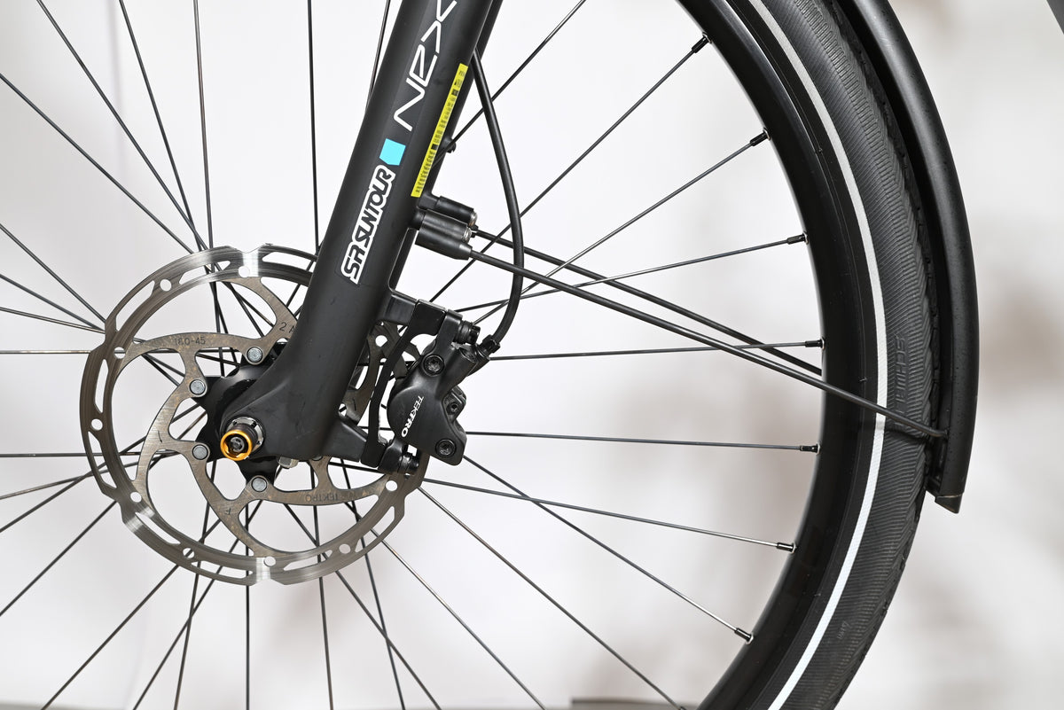 Gros plan sur la roue avant, le frein à disque Tektro et la fourche SR Suntour NEX du vélo Loop Sports Victoria eManufaktur