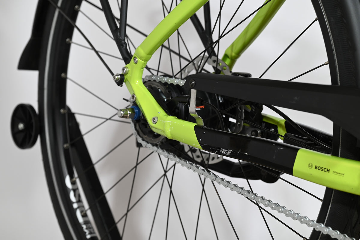 Gros plan sur la roue arrière et le cadre vert citron du vélo électrique Loop Sports Victoria eManufaktur 11.7