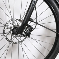 Gros plan sur la roue avant et le frein à disque hydraulique du vélo Loop Sports Victoria Manoc 5