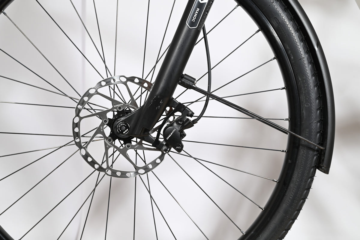 Gros plan sur la roue avant et le frein à disque hydraulique du vélo Loop Sports Victoria Manoc 5