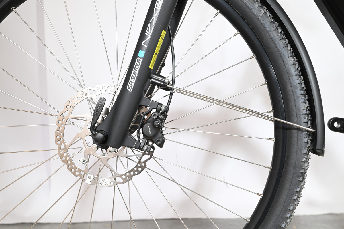 Gros plan sur la roue avant et le frein à disque hydraulique du vélo Loop Sports Victoria Trekking 11.5