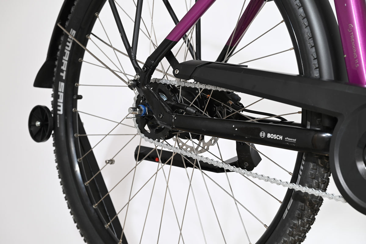 Gros plan sur la roue arrière et le cadre violet du vélo électrique Loop Sports Victoria Trekking 11.5 avec moteur Bosch