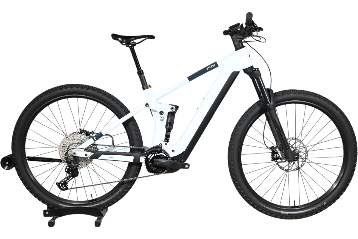 VTT électrique Cube Stereo Hybrid 140 HPC Pro 750 blanc et noir de Loop Sports sur un socle en bois