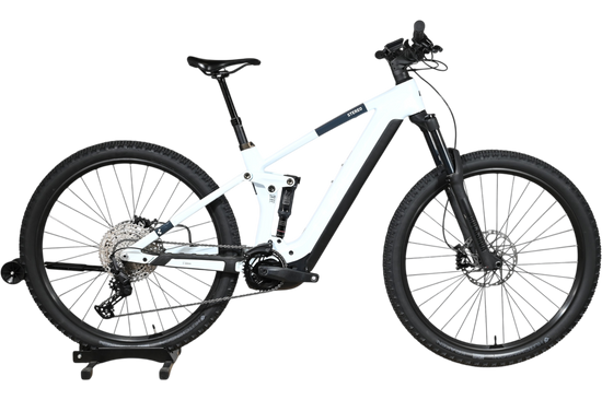 VTT électrique Cube Stereo Hybrid 140 HPC Pro 750 blanc et noir de Loop Sports sur un socle en bois