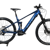 VTT électrique Sunn Charger S1 bleu de Loop Sports, cadre tout-suspendu avec pneus Hutchinson sur socle en bois