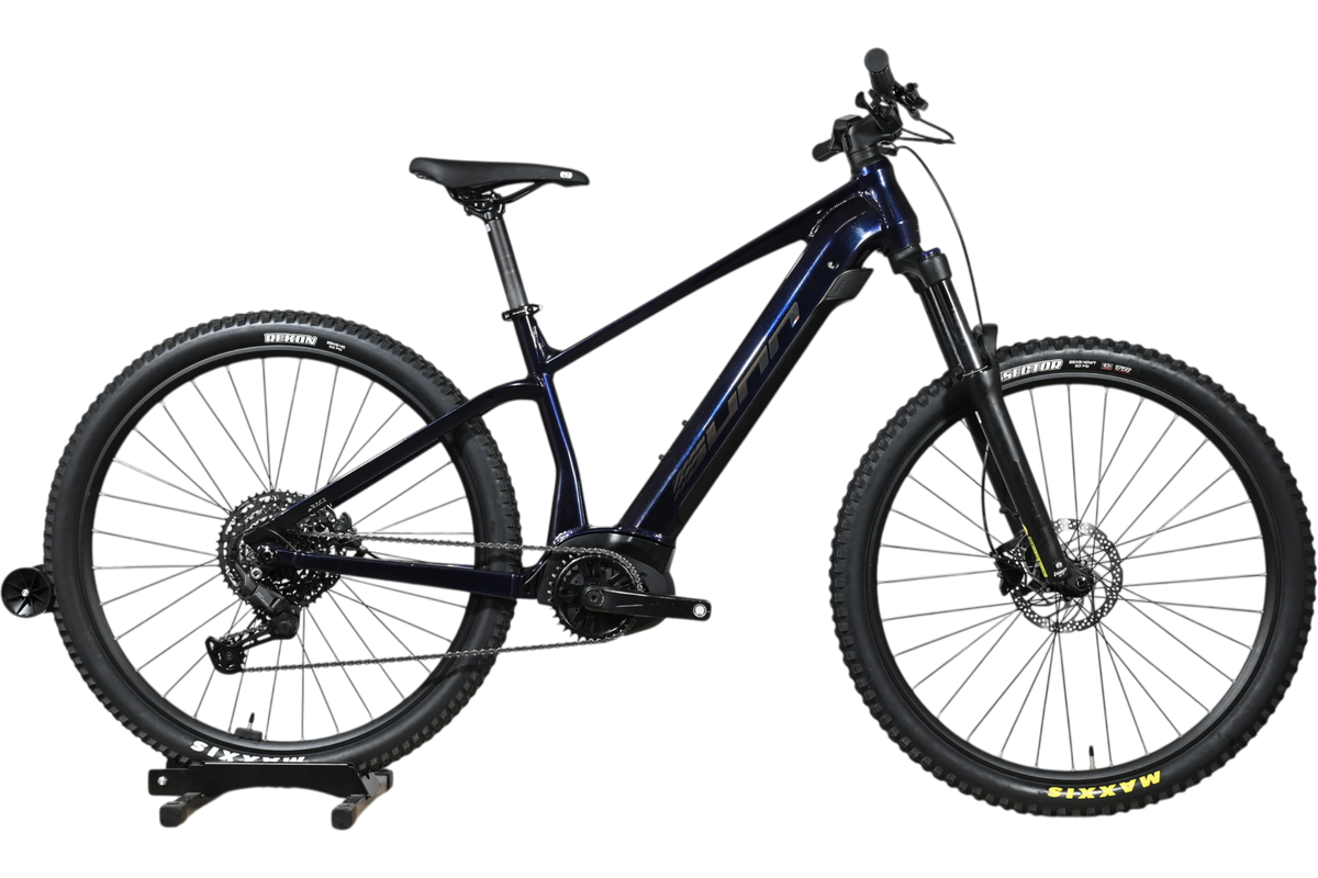 VTT électrique Sunn Rage S1 2025 bleu foncé de Loop Sports sur un socle en bois