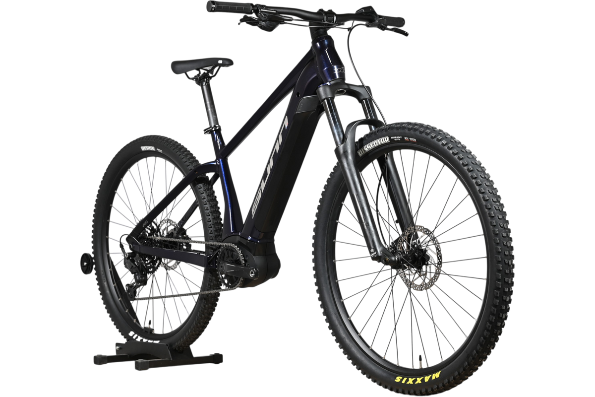 VTT électrique Sunn Rage S1 2025 bleu foncé de Loop Sports sur support en bois