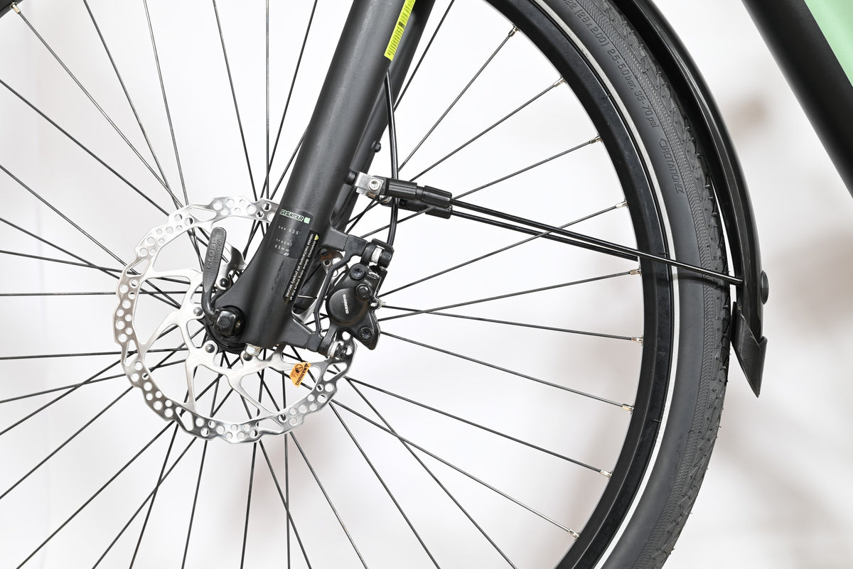 Gros plan sur la roue avant et le frein à disque hydraulique du vélo électrique Winora Sinus Tria N8 chez Loop Sports