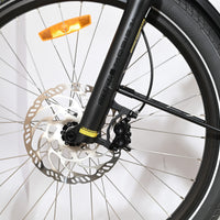 Gros plan sur la roue avant et la fourche suspendue SR Suntour Mobie 34 du vélo cargo Loop Sports Yuba Spicy Curry
