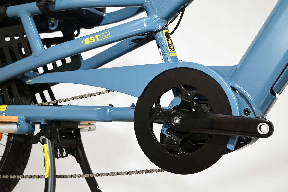 Gros plan sur le cadre bleu et le pédalier du vélo cargo électrique Loop Sports Yuba Spicy Curry Family Edition